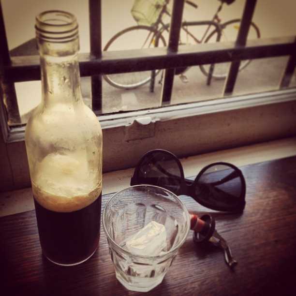 Hipster still life: bicycle, designer sunnies and cold drop coffee in a bottle